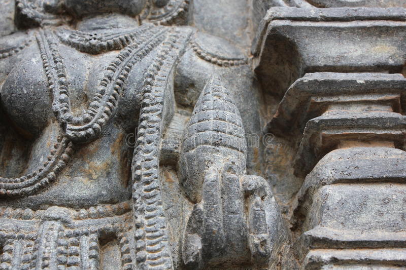 hoysaleswara-temple-wall-carving-depicting-god-holding-pine-cone-temple-wall-carving-depicting-god-holding-pine-cone-98627778.jpg